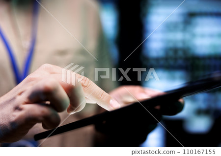 Developer doing thorough system upkeep, imputing data on tablet of required fixing in supercomputers housing advanced data storage hardware supporting complex computing operations, close up 110167155