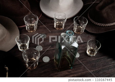 Bourbon shots with old west hats on table. Top view. Bourbon shots with old west hats on table. Top view. 110167445