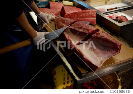 Tuna being fenced with a large knife Tuna being fenced with a large knife 110168686