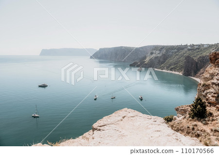 Aerial view from above on calm azure sea and volcanic rocky shores. Small waves on water surface in motion blur. Nature summer ocean sea beach background. Nobody. Holiday, vacation and travel concept Aerial view from above on calm azure sea and volcanic rocky shores. Small waves on water surface in motion blur. Nature summer ocean sea beach background. Nobody. Holiday, vacation and travel concept 110170566