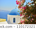 Blue sea, white cityscape, and pink flowers in Santorini, Greece 110172321