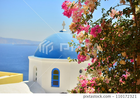 Blue sea, white cityscape, and pink flowers in Santorini, Greece Blue sea, white cityscape, and pink flowers in Santorini, Greece 110172321