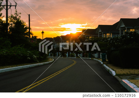 Modern cottages row road sidewalk two story buildings residential villas village New Estate Reflection dawn Sun in windows Modern cottages row road sidewalk two story buildings residential villas village New Estate Reflection dawn Sun in windows 110172916