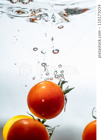 mini tomatoes falling into water 110173034