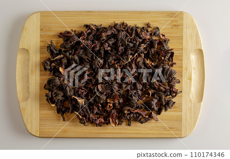 Tea made from dried pomegranate flowers. Increases immunity. Background of fragrant tea on a wooden board Tea made from dried pomegranate flowers. Increases immunity. Background of fragrant tea on a wooden board 110174346
