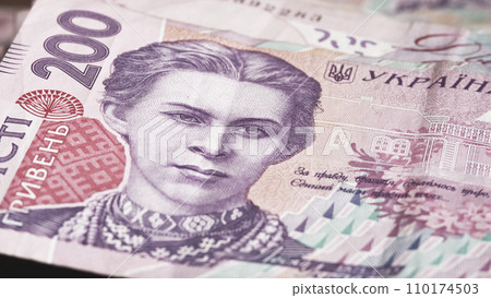 A close-up look at a 200 Ukrainian hryvnia banknote reveals the captivating portrayal of Lesya Ukrainka, showcasing the intricate details of Ukrainian paper currency. 110174503