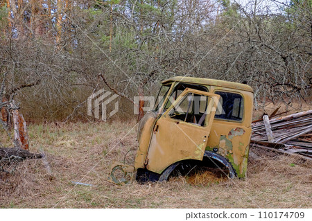 A rusted, abandoned car in a wooded area. A rusted, abandoned car in a wooded area. 110174709