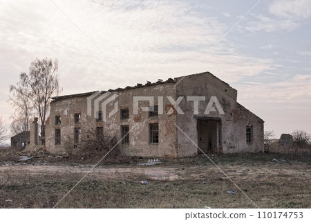 An abandoned structure surrounded by overgrown grass and bare trees. An abandoned structure surrounded by overgrown grass and bare trees. 110174753