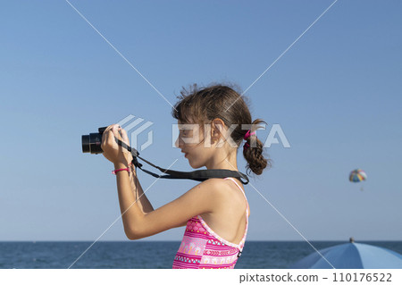 Adorable little girl taking photo by digital camera Adorable little girl taking photo by digital camera 110176522