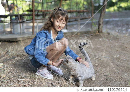 Young child girl having fun with cat in the sunset Young child girl having fun with cat in the sunset 110176524