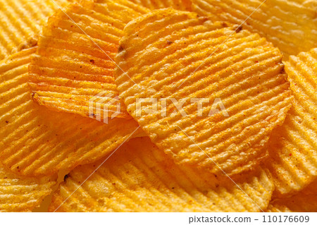 macro of beautiful corrugated yellow chips under the sun's rays 110176609