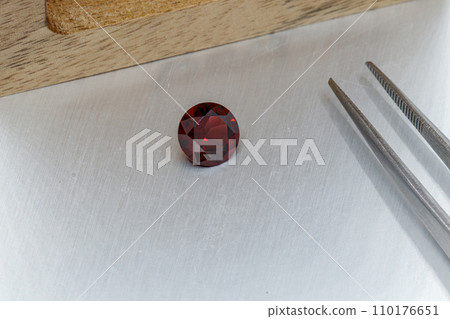 macro mineral faceted stone cut Garnet on a gray background 110176651