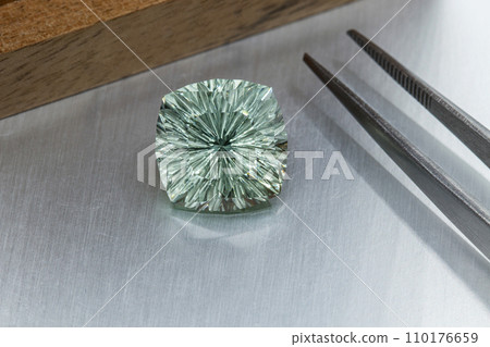 macro mineral faceted stone cut Beryl on a gray background macro mineral faceted stone cut Beryl on a gray background 110176659