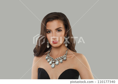Stylish glamorous woman jewelry model with diamonds posing on gray background Stylish glamorous woman jewelry model with diamonds posing on gray background 110177340