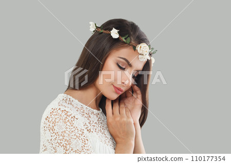 Bride woman brunette with long dark healthy wavy hair and makeup  on gray background 110177354