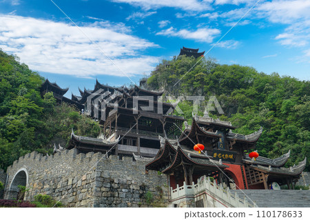 The brown and black stilted buildings are built according to the mountain. The brown and black stilted buildings are built according to the mountain. 110178633