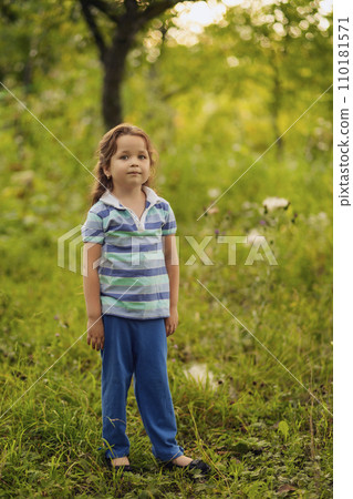 A girl stands near a tree 110181571
