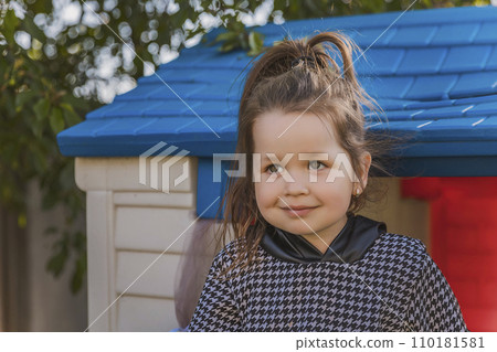 portrait of a little girl playing outdoors 110181581