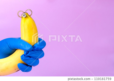 Intimate piercing. Minimal piercing concept. Banana with inserted iron decoration, piercing 110181759