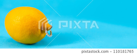 Intimate piercing. Minimal piercing concept. Lemon with inserted iron decoration, piercing Intimate piercing. Minimal piercing concept. Lemon with inserted iron decoration, piercing 110181765