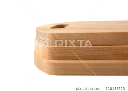 Close-up of the edges of three wooden cutting boards on a white background. 110183513