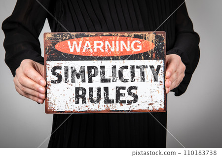 Simplicity Rules. Warning sign in woman's hands Simplicity Rules. Warning sign in woman's hands 110183738