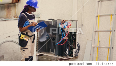 Professional wireman commissioned for external air conditioner routine check up, writing findings on clipboard. Specialist doing hvac system investigation of damaged parts Professional wireman commissioned for external air conditioner routine check up, writing findings on clipboard. Specialist doing hvac system investigation of damaged parts 110184377