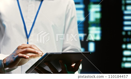 Electrician in server hub walking through supercomputers used for computationally intensive tasks such as scientific simulations or 3D rendering. Wireman doing annual equipment checkup Electrician in server hub walking through supercomputers used for computationally intensive tasks such as scientific simulations or 3D rendering. Wireman doing annual equipment checkup 110184457