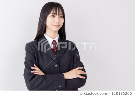 A high school girl with her arms crossed and a confident face 110185260