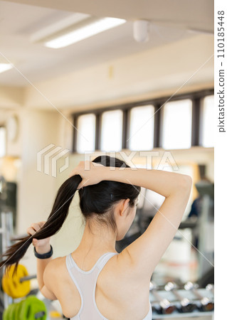 Young woman tying her hair up before exercising 110185448