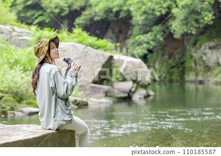 一位女士在河床上享受觀鳥的樂趣 一位女士在河床上享受觀鳥的樂趣 110185587