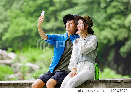 Young couple taking pictures at the campsite 110185671