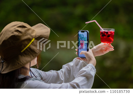 Young woman having a nice drink outdoors 110185730