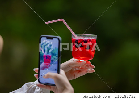 年輕女子在戶外喝一杯美酒 110185732