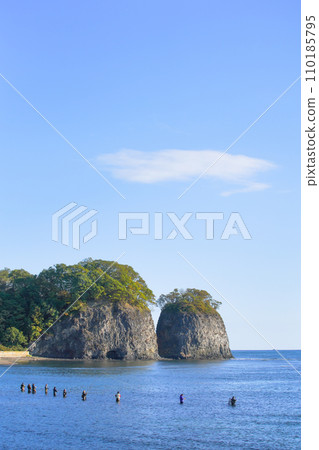 北海道網走市的二津岩和清晨陽光照射下的海裡釣魚的人們 北海道網走市的二津岩和清晨陽光照射下的海裡釣魚的人們 110185795