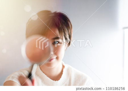 woman looking through a magnifying glass woman looking through a magnifying glass 110186256
