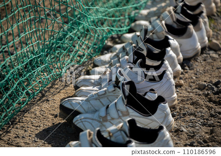 Baseball shoes lined up on the ground 110186596