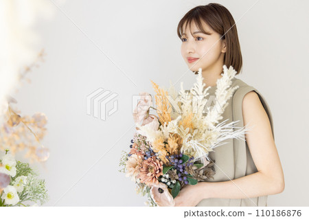 One-piece woman holding a bouquet of dried flowers 110186876