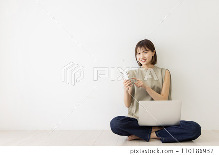 Young woman using laptop and smartphone 110186932