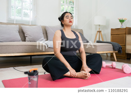 Cheerful attractive young overweight woman in activewear choosing healthy lifestyle Cheerful attractive young overweight woman in activewear choosing healthy lifestyle 110188291