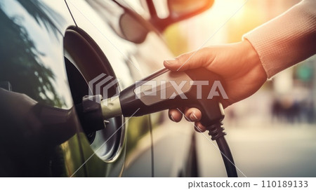 the hand of a man charging an electric car 110189133