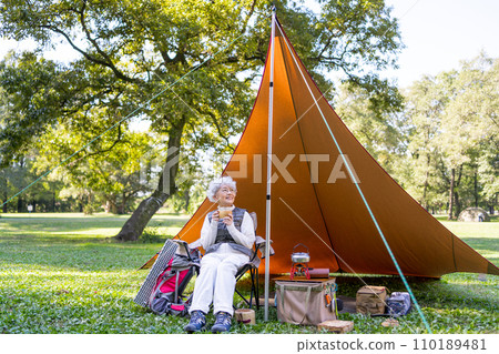 A woman in her 60s enjoying camping A woman in her 60s enjoying camping 110189481