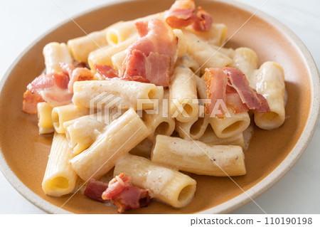 spaghetti rigatoni pasta with white sauce and bacon 110190198