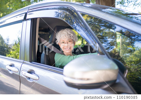 Elderly woman driving a car Elderly woman driving a car 110190385