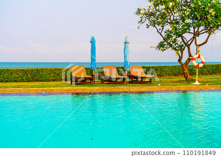 chair pool or bed pool and umbrella around swimming pool with sea background chair pool or bed pool and umbrella around swimming pool with sea background 110191849
