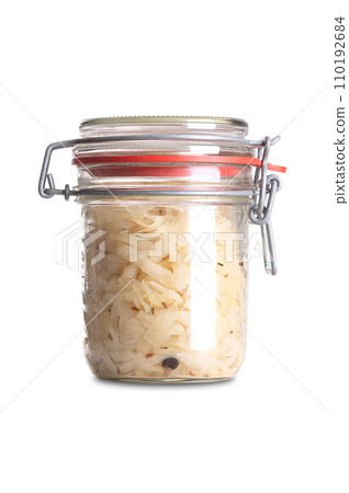German sauerkraut, in swing top glass jar, front view. Cut raw cabbage, fermented by lactic acid bacteria. Traditionally a warm served side dish, flavored with juniper berries and caraway seeds. Photo German sauerkraut, in swing top glass jar, front view. Cut raw cabbage, fermented by lactic acid bacteria. Traditionally a warm served side dish, flavored with juniper berries and caraway seeds. Photo 110192684