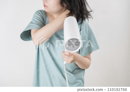 young woman using a hair dryer 110192788