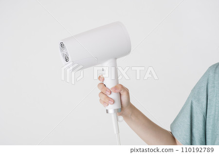 young woman with hair dryer 110192789
