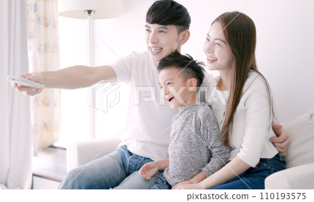 Happy Asian family watching TV together at hom Happy Asian family watching TV together at hom 110193575
