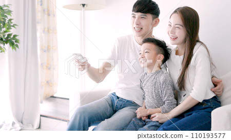 Happy Asian family watching TV together at hom Happy Asian family watching TV together at hom 110193577
